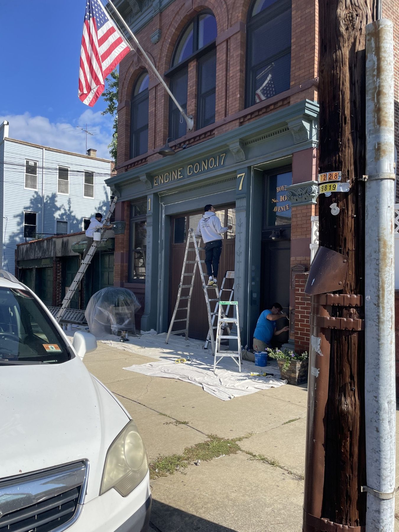Yarussi masons on ladders restoring the red brick facade of a historic firehouse, Engine Co. No. 17