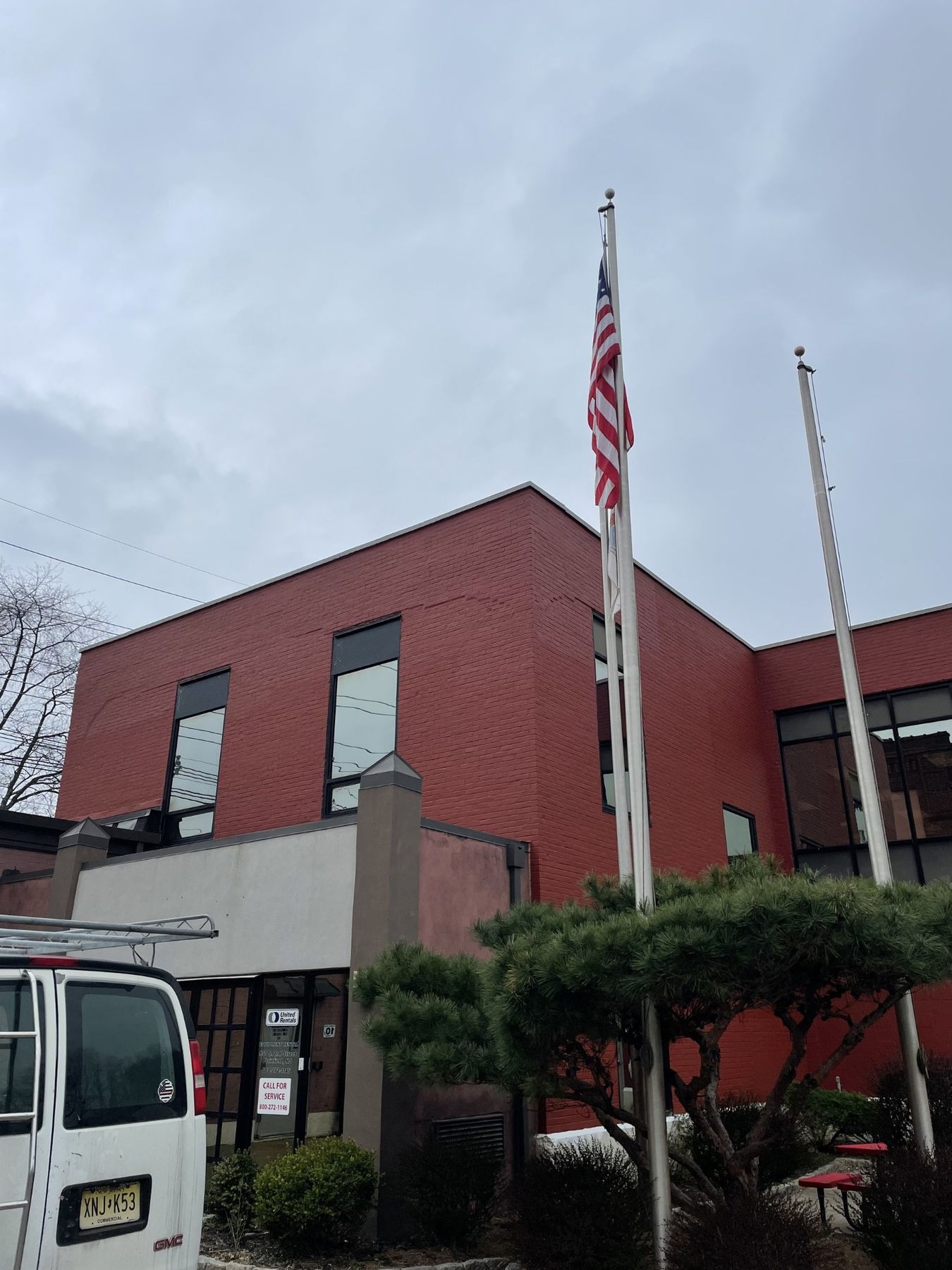Red brick office building photographed from below with American flags flying in front